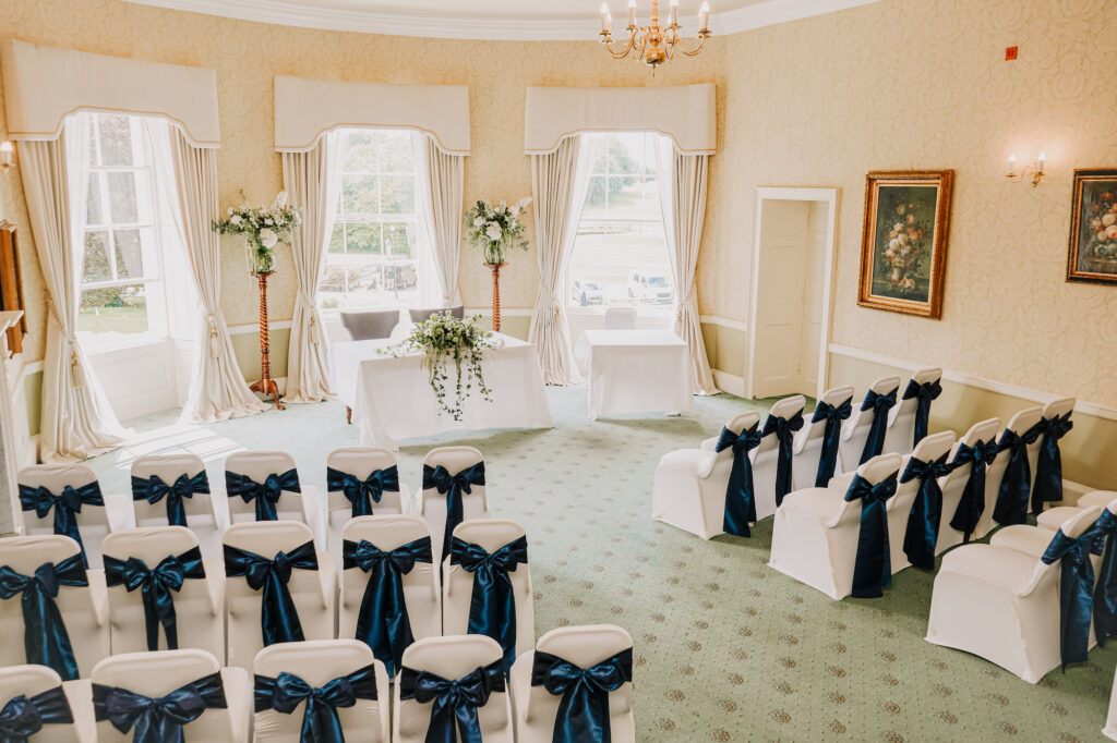 A wedding in the De Lacey Suite at Owston Hall Hotel Doncaster white chair covers and blue sashes