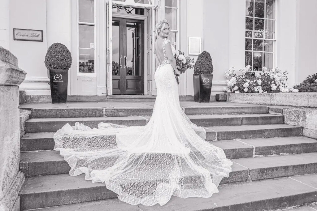 Bride on the steps with a long wedding dress train at Owston Hall Hotel Doncaster